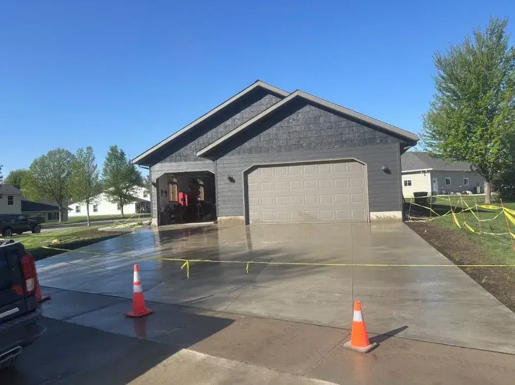 Freshly poured concrete driveway in front of a two-car garage