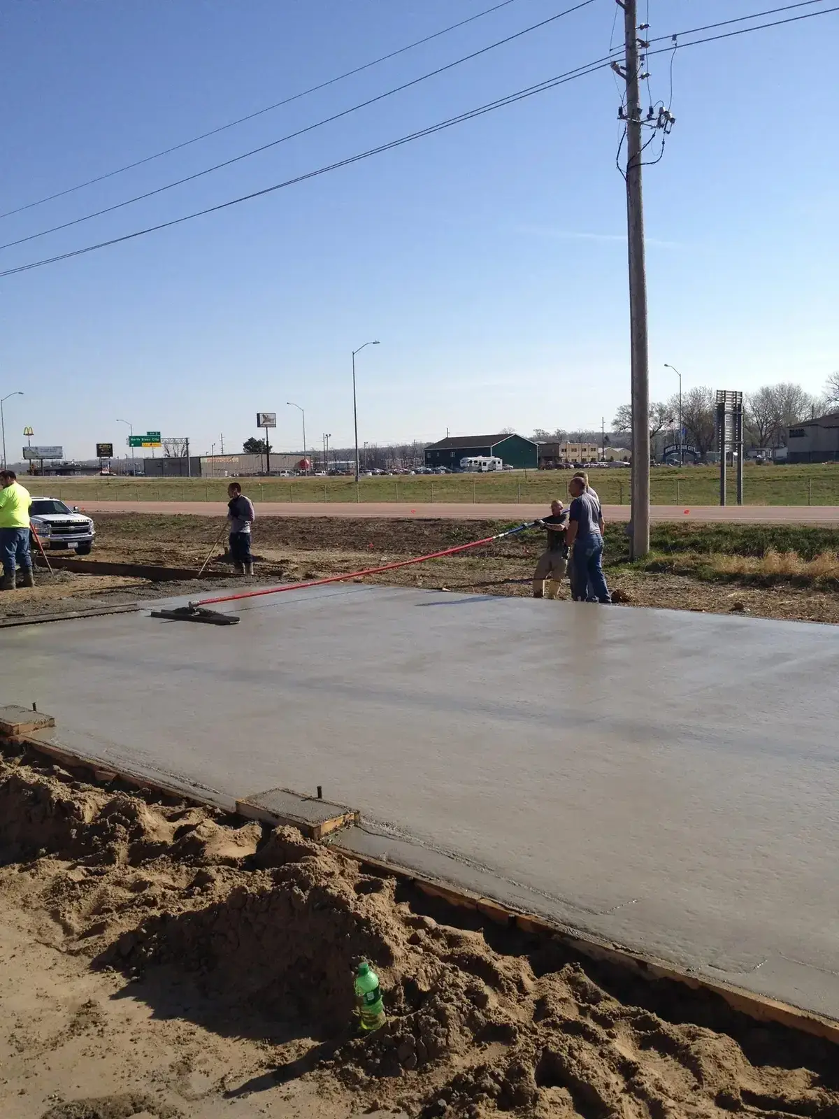 Crew screeding a large commercial concrete slab