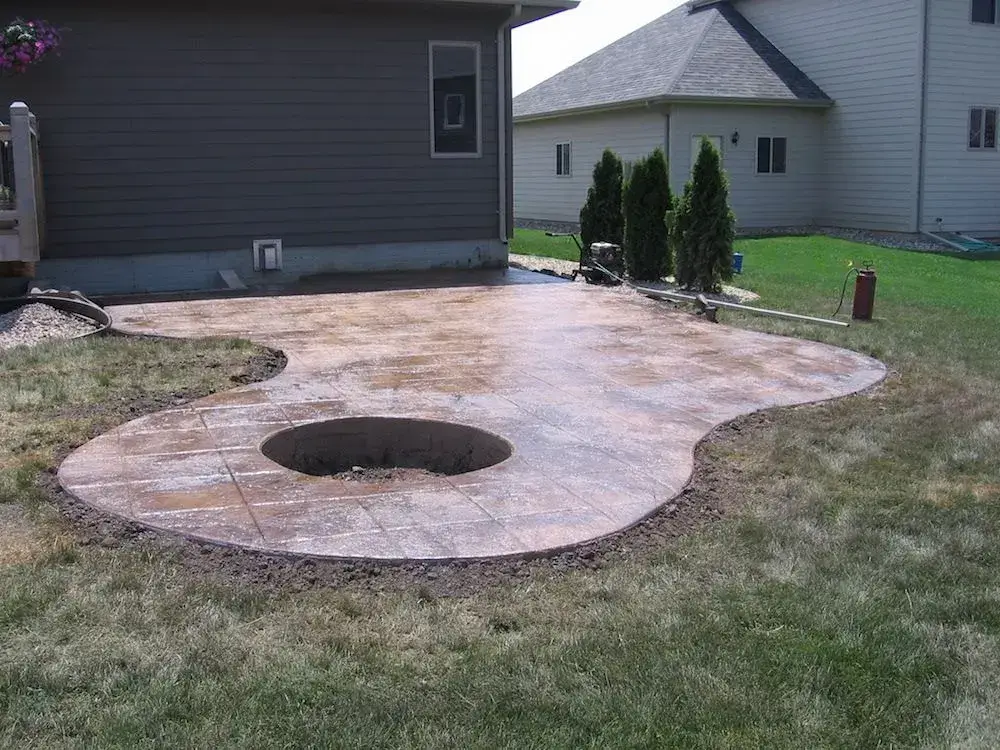 Stamped and colored concrete patio with an in-ground fire pit