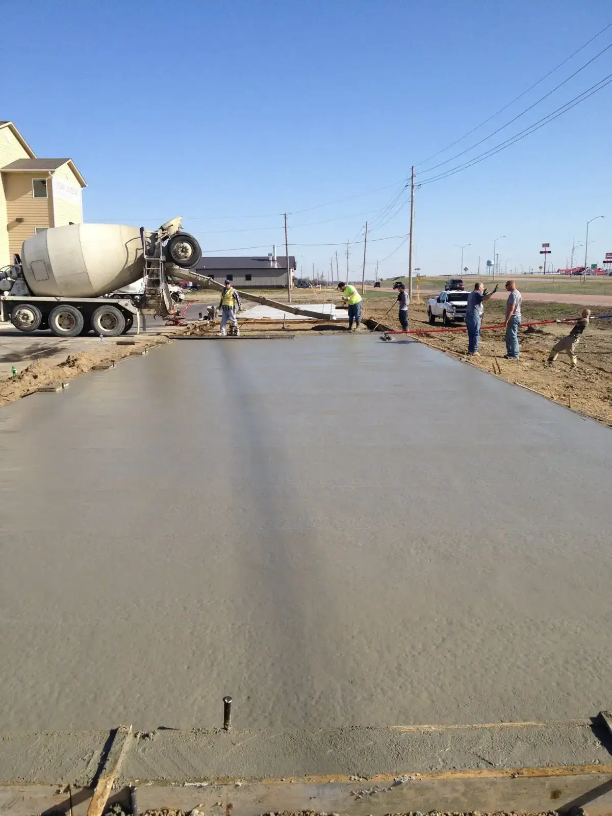 Crew placing a large commercial concrete slab from a mixer truck