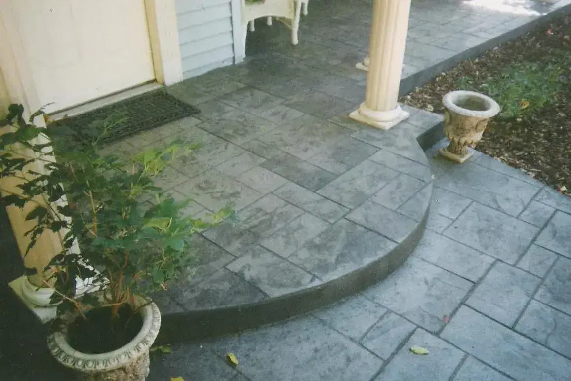 Stamped concrete front entry walkway with a curved step