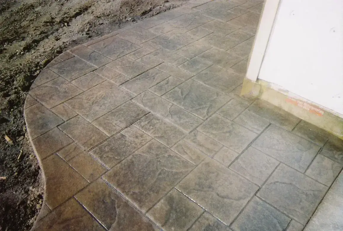 Curved stamped concrete walkway along a house